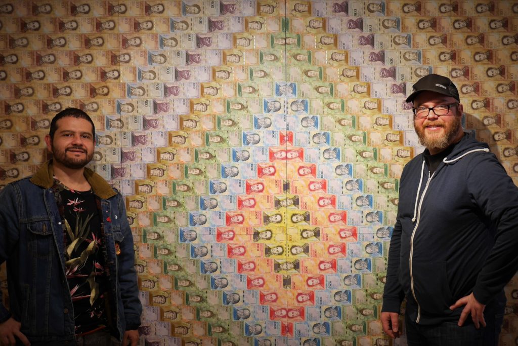 Andrés Chapparo, left, and Justin Rovig use defunct Venezuelan bolivar notes in their Bogotá art show this month. Photo: Steve Hide.