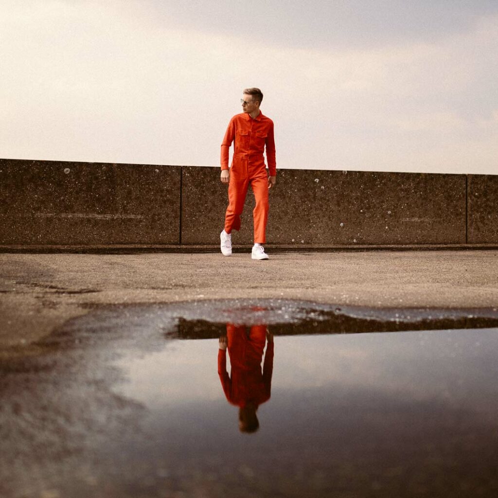 Joris Voorn reflected in large puddle.