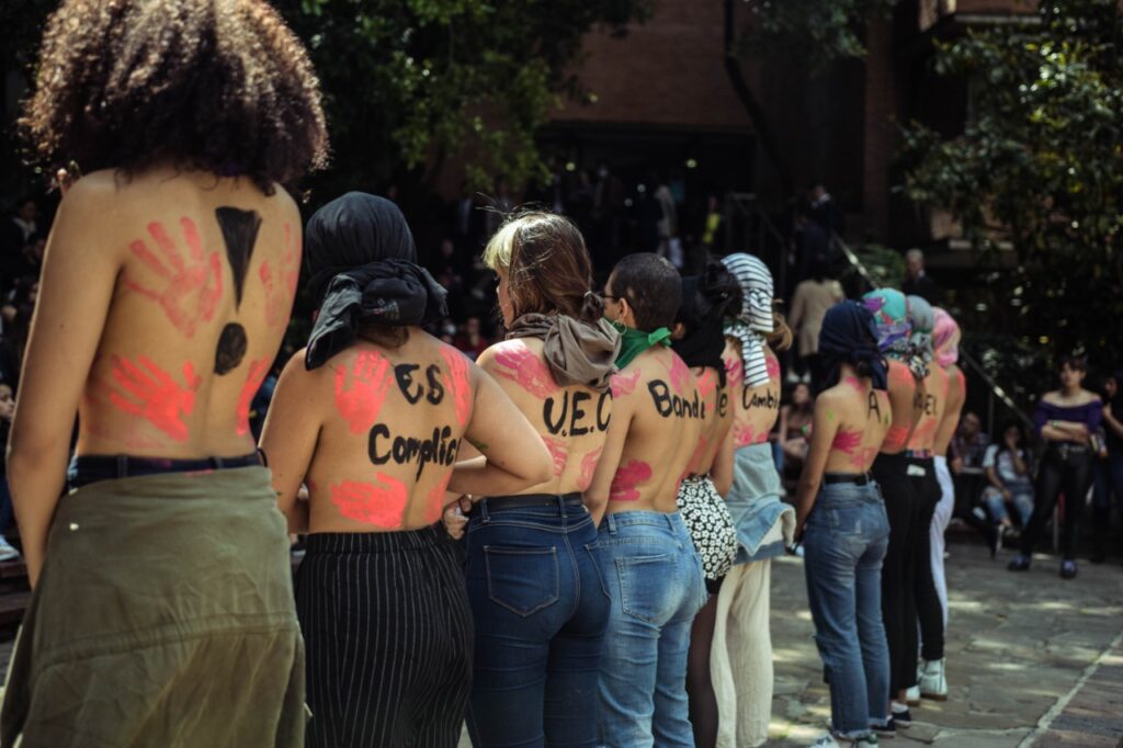 A line of female students show their bare backs in protest.