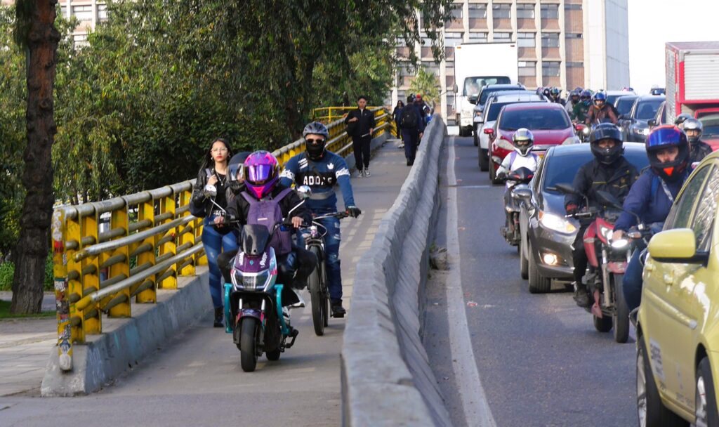 Pedestrians, bicycles and e-bikes already share Bogotá's congested footpaths. The problem could get worse with planned legislation to allow larger motorbikes. Photo: Steve Hide